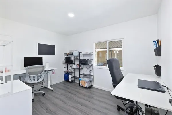 a view of a workspace with furniture and a window