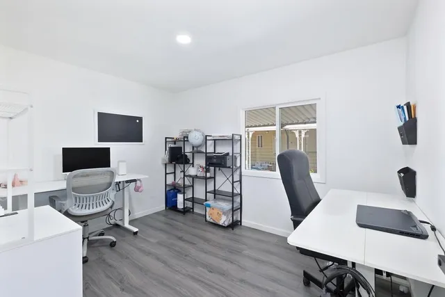 a view of a workspace with furniture and a window