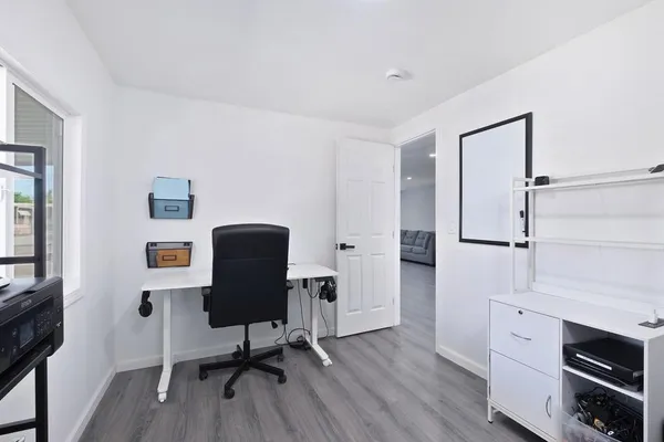 a view of a workspace with furniture and wooden floor