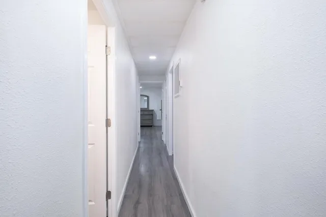 a view of a hallway with wooden floor