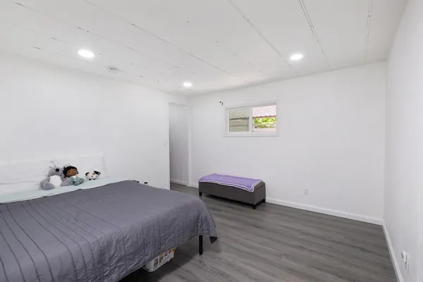 a bedroom with a bed and a wooden floor