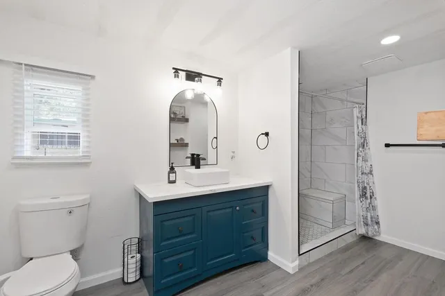 a bathroom with a toilet sink and mirror