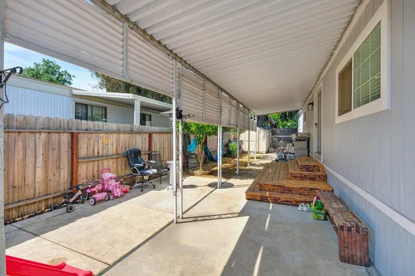a view of a patio with table and chairs potted plants with wooden floor and fence
