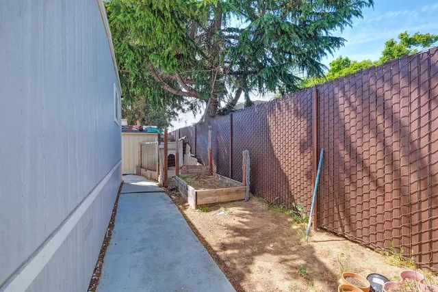 a view of a backyard with wooden fence and a bench