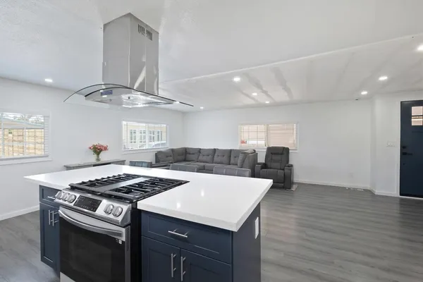 a kitchen that has a sink a stove and a table in it