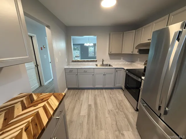 a kitchen with a refrigerator sink and cabinets