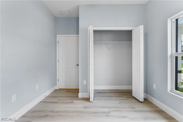 an empty room with wooden floor and entrance