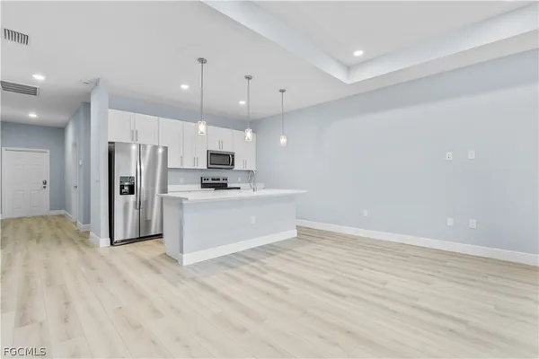 a view of kitchen with stainless steel appliances kitchen island a refrigerator sink and cabinets