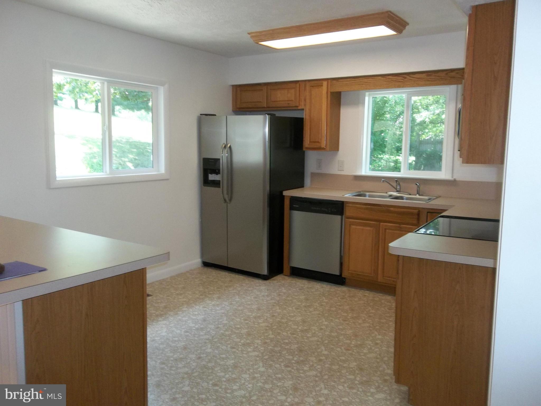 6038 Howellsville Road Front Royal, VA 22630 - Photo 17 of 30 a kitchen with stainless steel appliances granite countertop a refrigerator a sink a stove a washer dryer and white cabinets