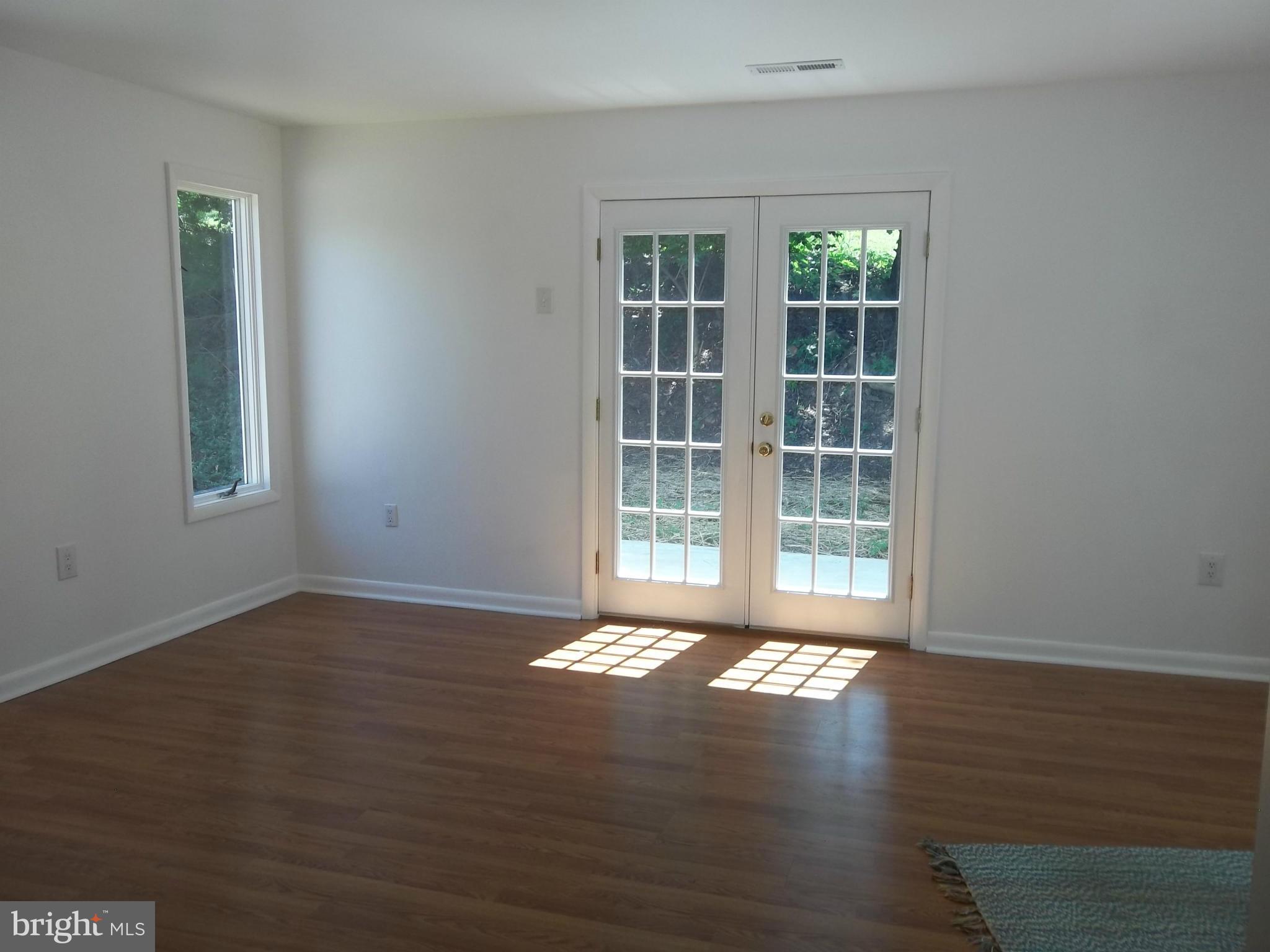6038 Howellsville Road Front Royal, VA 22630 - Photo 20 of 30 a view of an empty room with wooden floor and a window