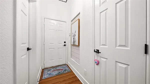 a view of a hallway with wooden floor and entryway