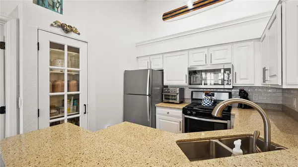a kitchen with stainless steel appliances kitchen island a refrigerator sink and cabinets
