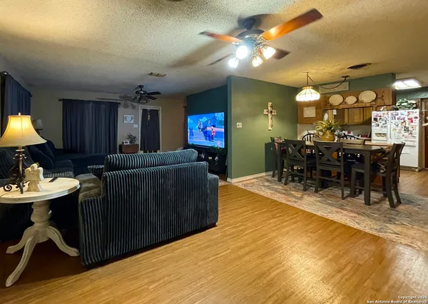 a living room with furniture a dining table and kitchen view