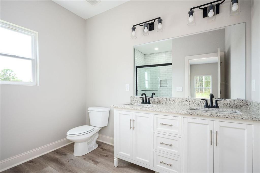 301 C W Sims Road Hiram, GA 30141 - Photo 17 of 29 a bathroom with a granite countertop toilet sink and mirror