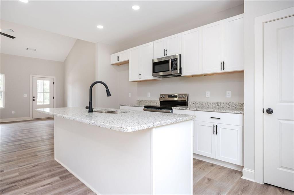 301 C W Sims Road Hiram, GA 30141 - Photo 9 of 29 a kitchen with stainless steel appliances granite countertop a sink a stove a microwave and cabinets