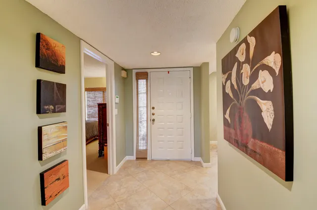 a kitchen with stainless steel appliances granite countertop a refrigerator a sink a stove a dining table and chairs