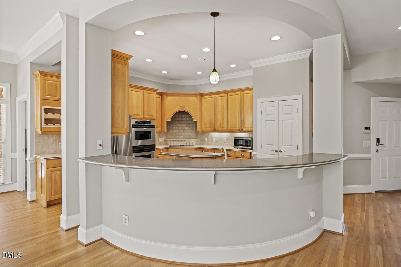 4004 Frontenac Court Apex, NC 27539 - Photo 18 of 61 a kitchen with kitchen island granite countertop a sink window and refrigerator