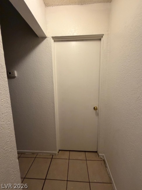 521 North Decatur Boulevard, Unit B Las Vegas, NV 89107 - Photo 12 of 17 A simple interior hallway featuring durable tiled flooring and a classic door.
