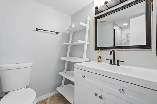 a bathroom with a sink a toilet a mirror and vanity