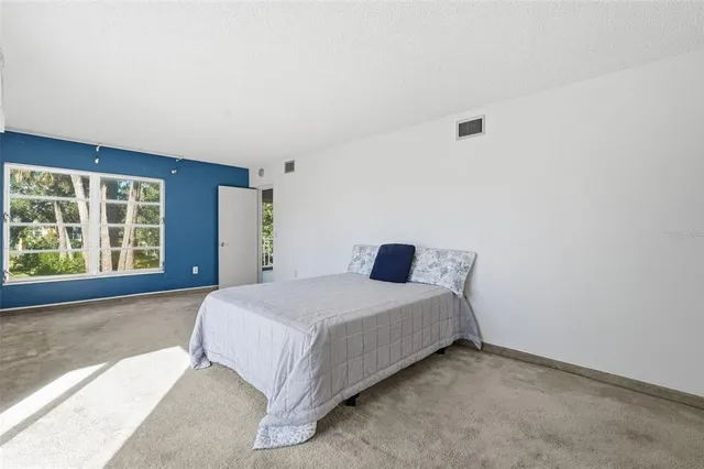 a spacious bedroom with a bed and a window