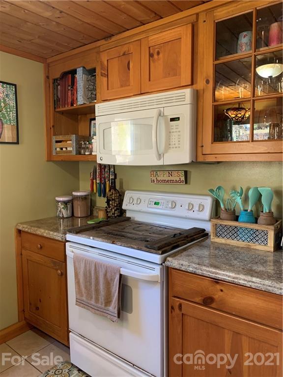1321 Orchard Road Deep Gap, NC 28618 - Photo 18 of 40 a kitchen with granite countertop a stove a cabinets and a wooden floor