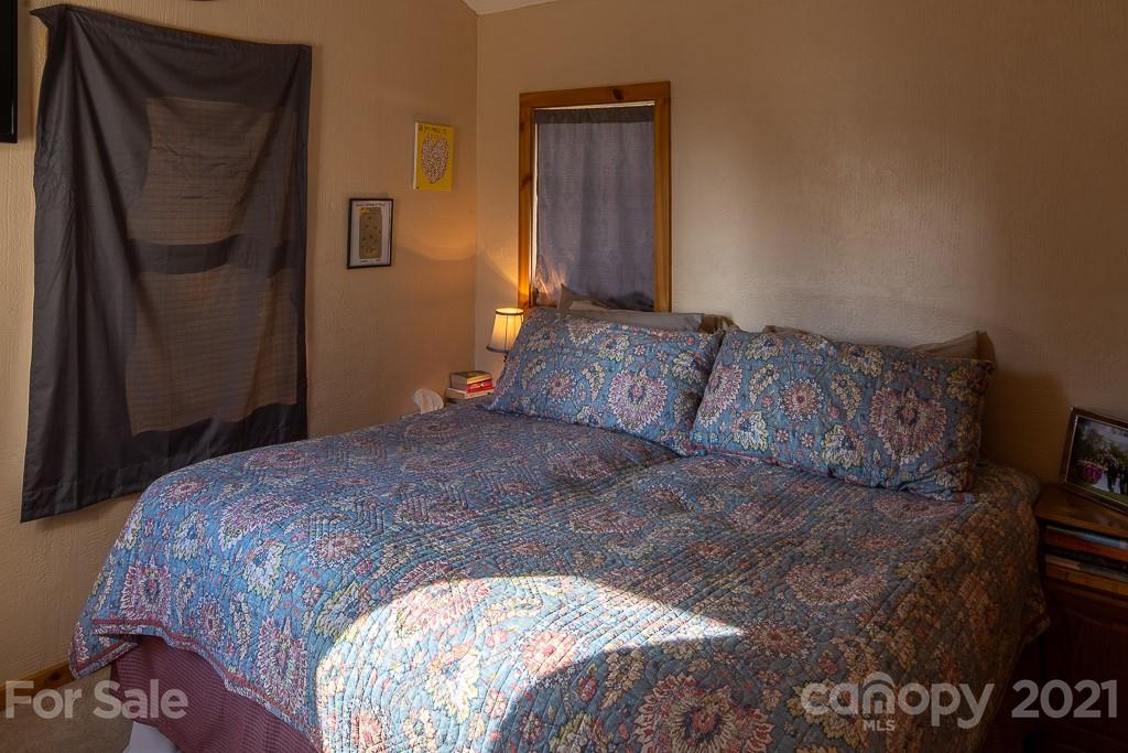 1321 Orchard Road Deep Gap, NC 28618 - Photo 27 of 40 a bedroom with a bed and a mirror