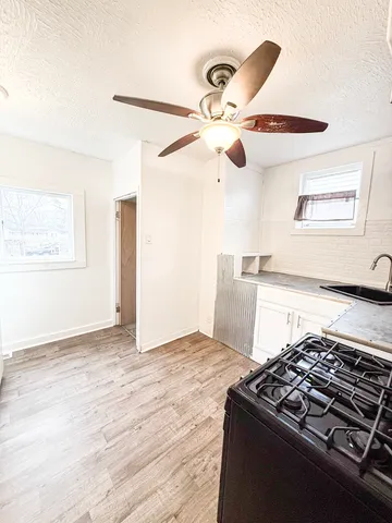a kitchen with kitchen island stainless steel appliances a stove and a ceiling fan