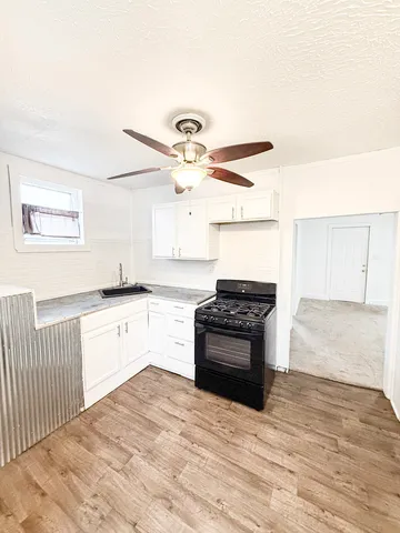 a kitchen with granite countertop a stove and a sink