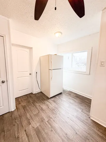 an empty room with wooden floor and white wall