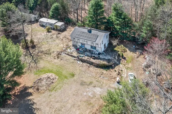 a view of a house with backyard and trees