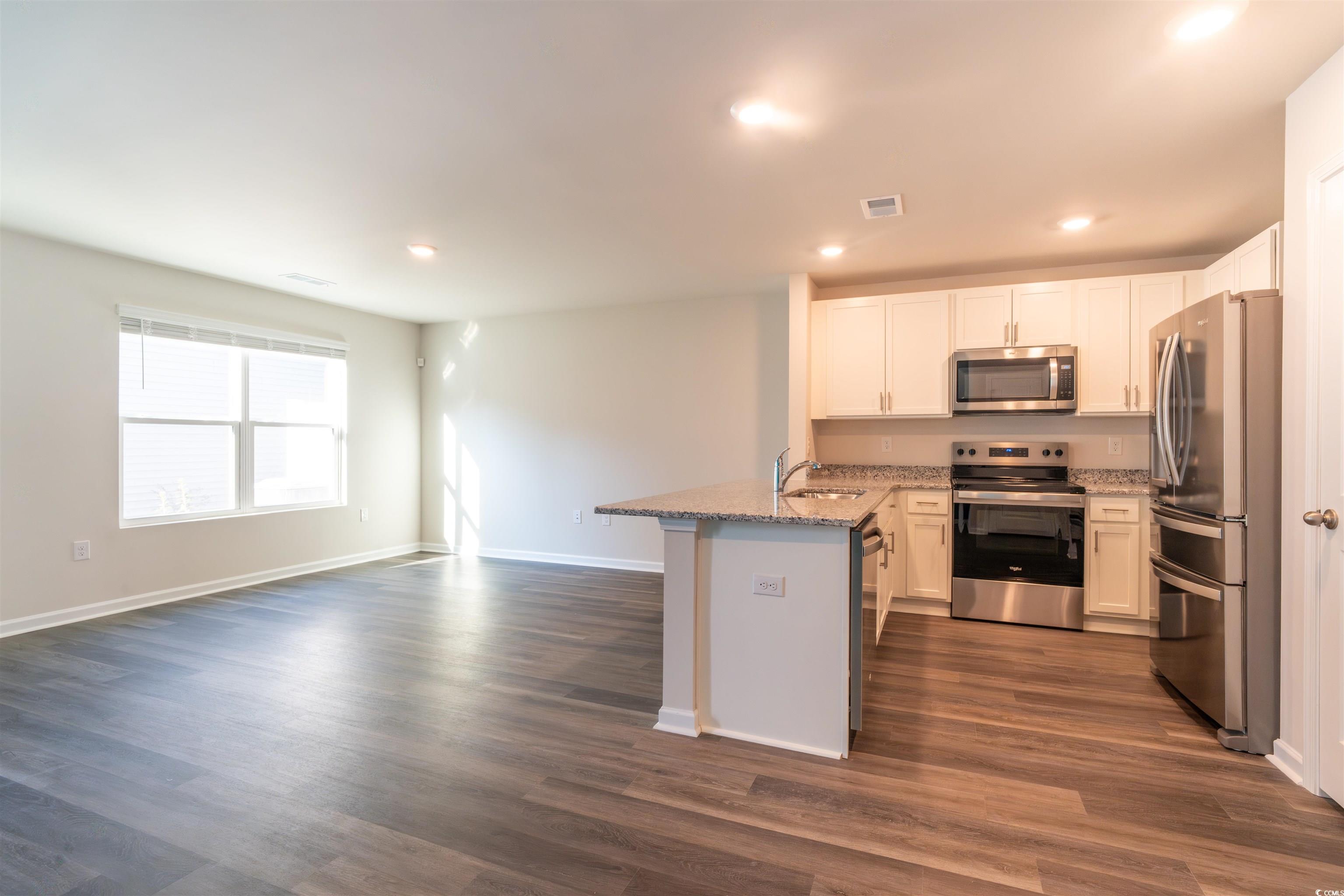 160 Harvest Gold Drive Conway, SC 29526 - Photo 35 of 37 Kitchen featuring stainless steel appliances, white cabinets, a peninsula, light stone countertops, and open floor plan