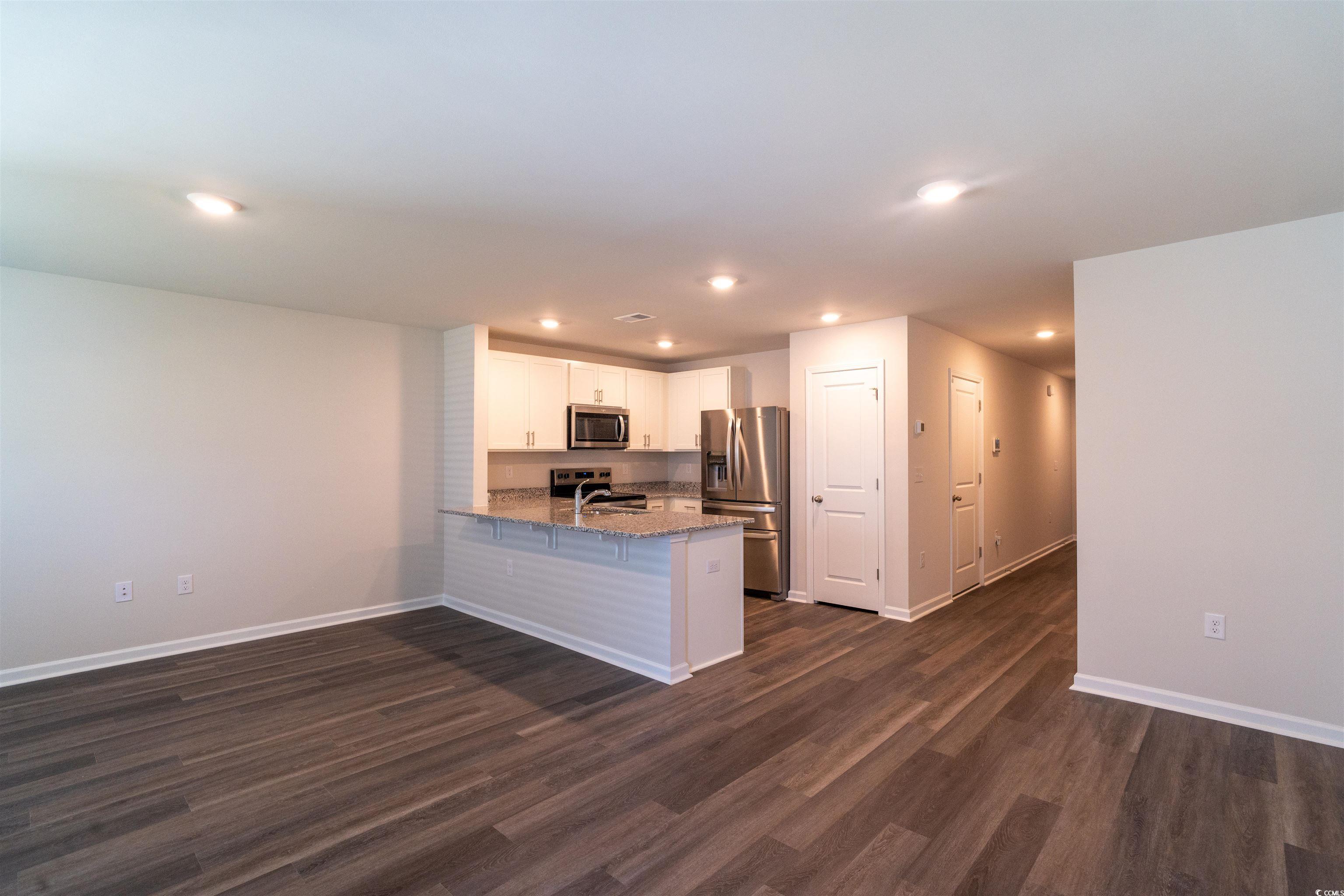 160 Harvest Gold Drive Conway, SC 29526 - Photo 4 of 37 Kitchen with a peninsula, white cabinetry, appliances with stainless steel finishes, light stone counters, and recessed lighting