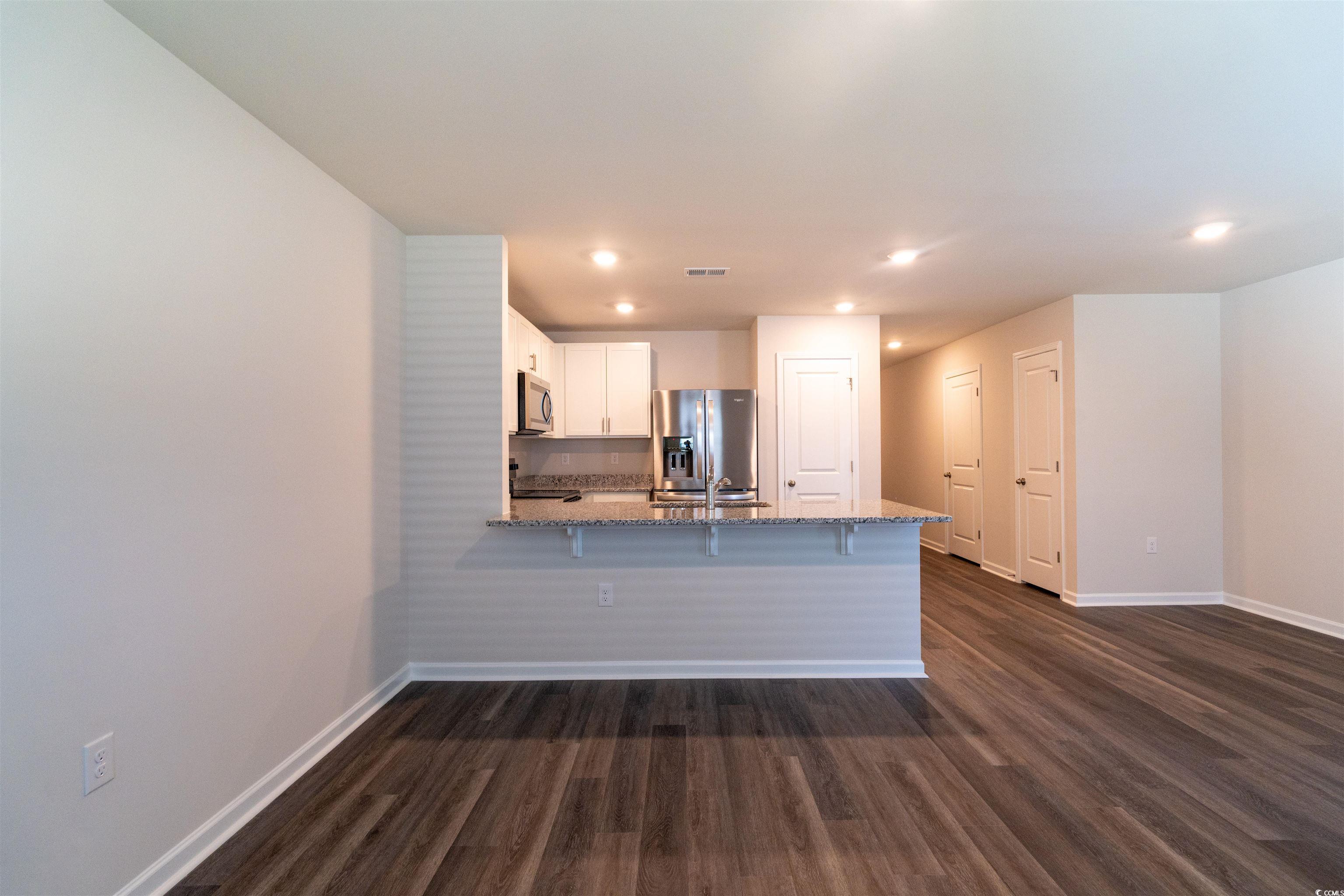 160 Harvest Gold Drive Conway, SC 29526 - Photo 5 of 37 Kitchen with a peninsula, white cabinetry, light stone counters, appliances with stainless steel finishes, and a kitchen breakfast bar
