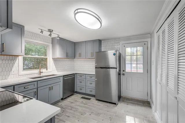 a kitchen with a refrigerator sink and cabinets
