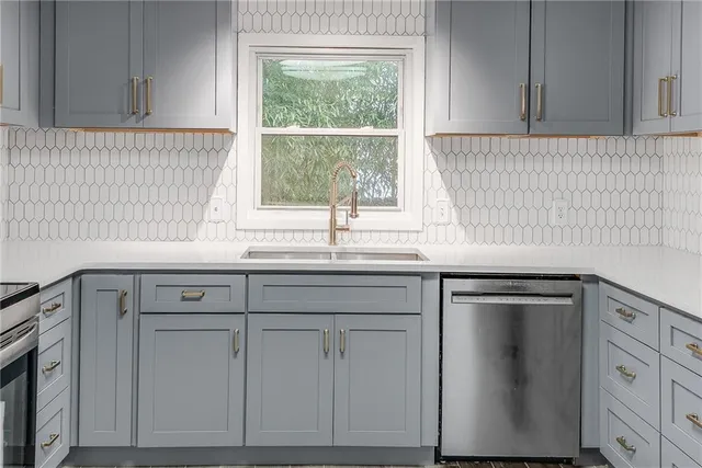 a kitchen with white cabinets and a window