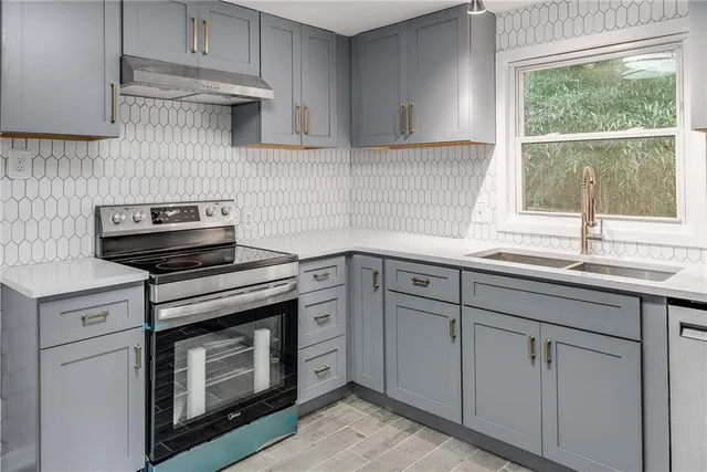 a kitchen with white cabinets and a stove