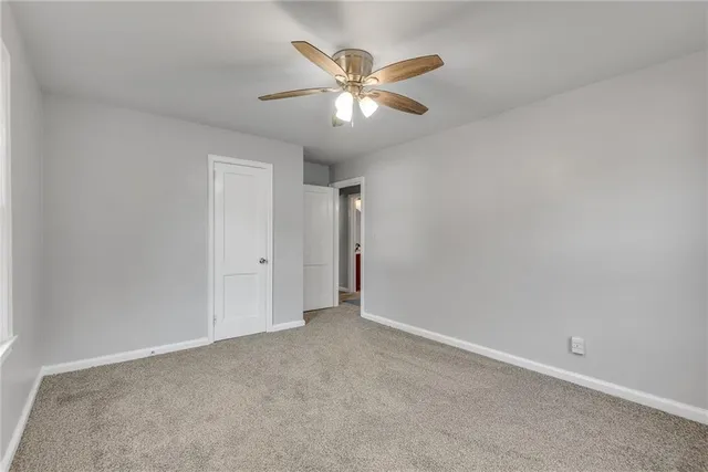 an empty room with closet and ceiling fan