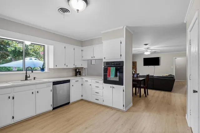 a kitchen with granite countertop a sink cabinets and wooden floor