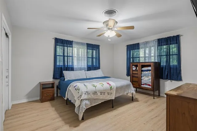 a bedroom with a bed a dresser and a chandelier