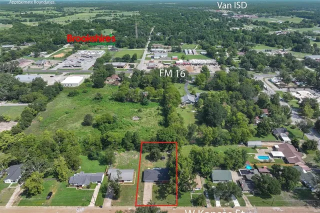 an aerial view of residential houses with outdoor space and trees