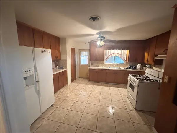 a kitchen with granite countertop a refrigerator and a stove top oven