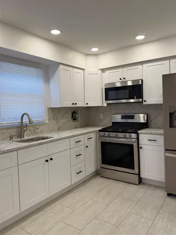 a kitchen with stainless steel appliances granite countertop a stove and a sink