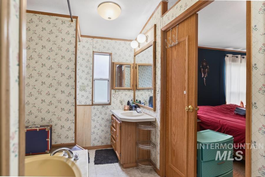 609 North Almon Street, Unit 3024 Moscow, ID 83843 - Photo 11 of 17 Bathroom featuring wallpapered walls, vanity, ensuite bathroom, a bath, and crown molding