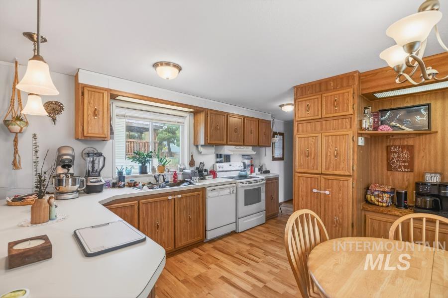 609 North Almon Street, Unit 3024 Moscow, ID 83843 - Photo 5 of 17 Kitchen featuring pendant lighting, light countertops, brown cabinets, and white appliances