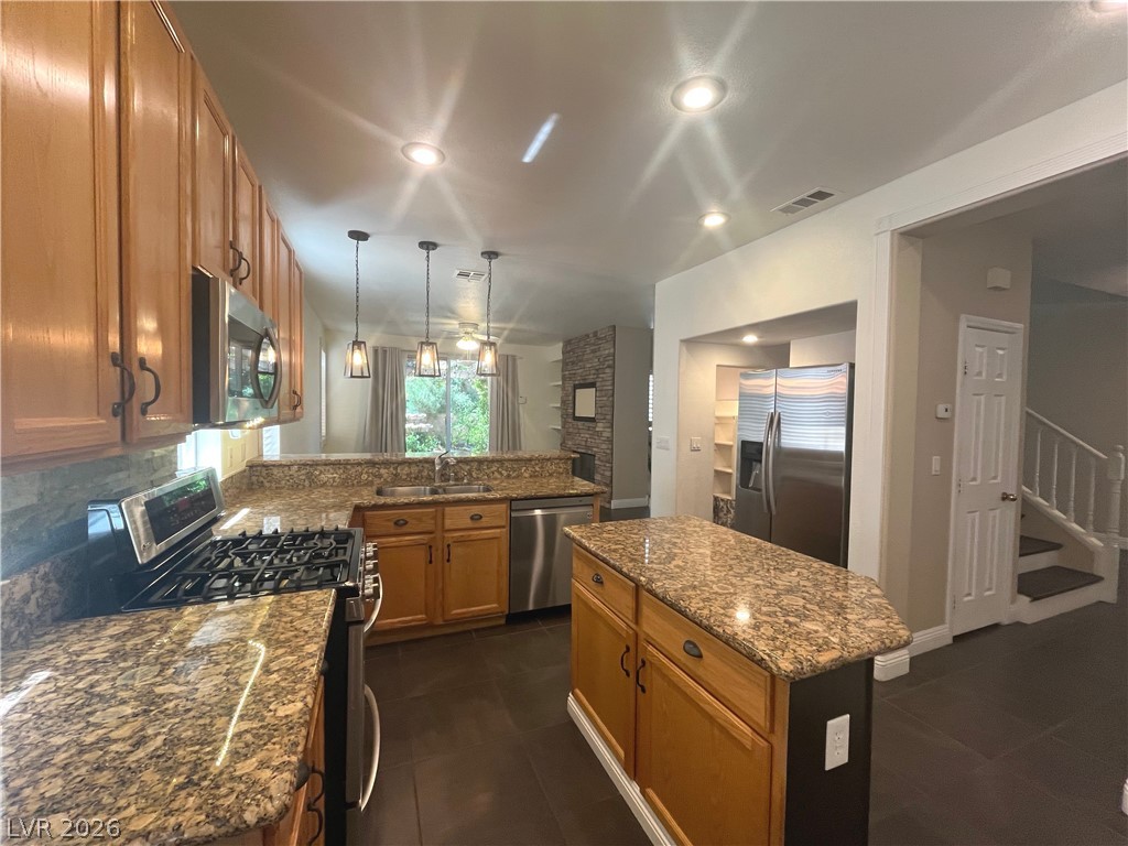 1809 Snow Spring Lane Las Vegas, NV 89134 - Photo 11 of 75 Kitchen w/island & breakfast bar w/granite counters, SS appl, recessed & pendant lights, ceramic tile floors, oak cabinets, dining nook w/add'l cabinets & pantry