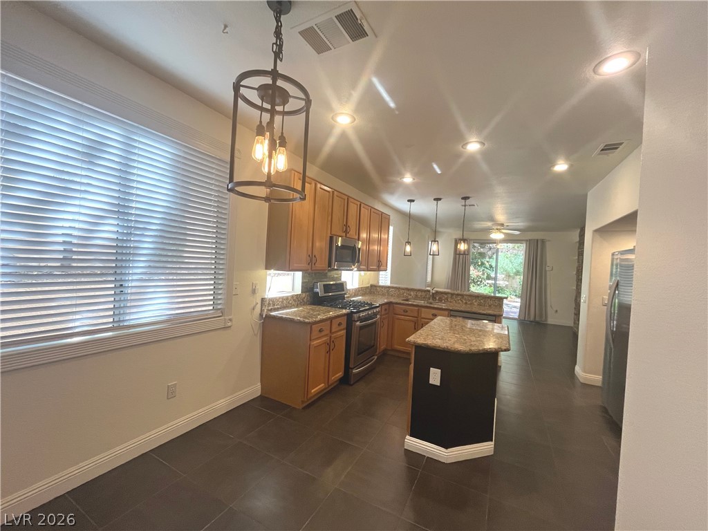 1809 Snow Spring Lane Las Vegas, NV 89134 - Photo 13 of 75 Kitchen w/island & breakfast bar w/granite counters, SS appl, recessed & pendant lights, ceramic tile floors, oak cabinets, dining nook w/add'l cabinets & pantry