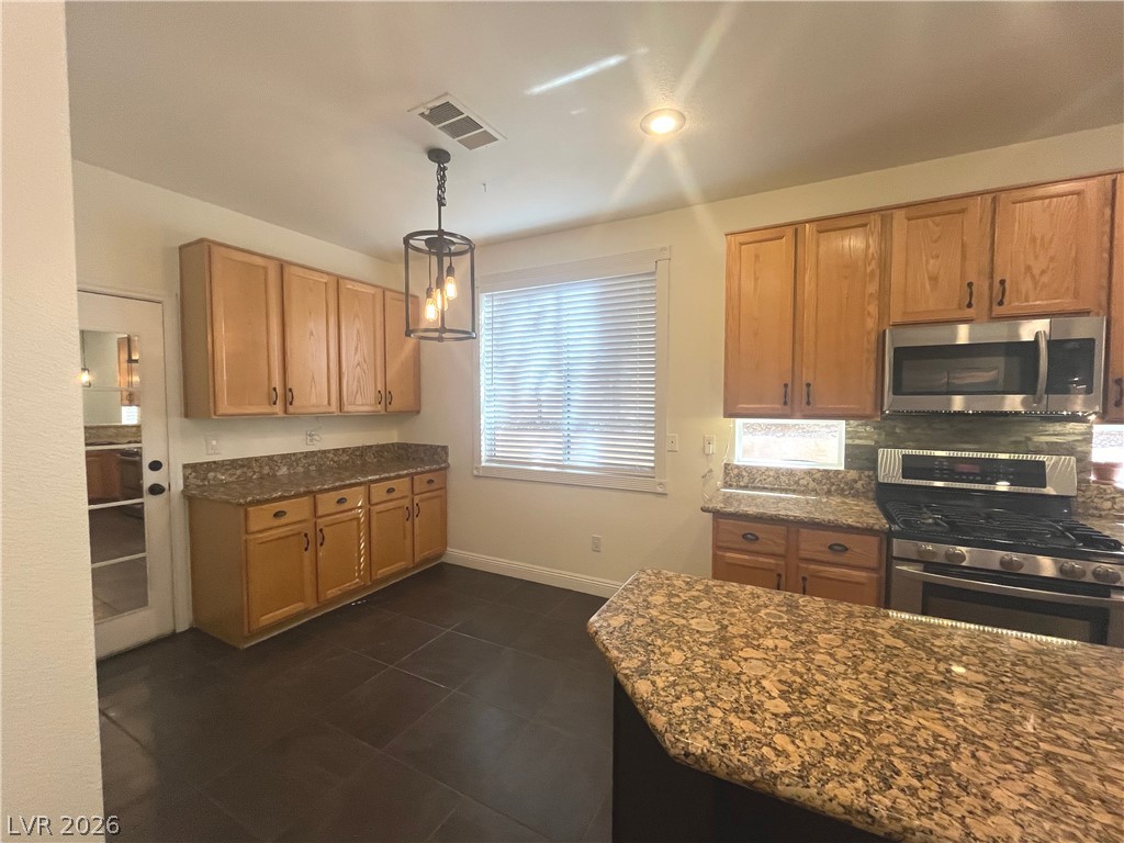 1809 Snow Spring Lane Las Vegas, NV 89134 - Photo 14 of 75 Kitchen w/island & breakfast bar w/granite counters, SS appl, recessed & pendant lights, ceramic tile floors, oak cabinets, dining nook w/add'l cabinets & pantry
