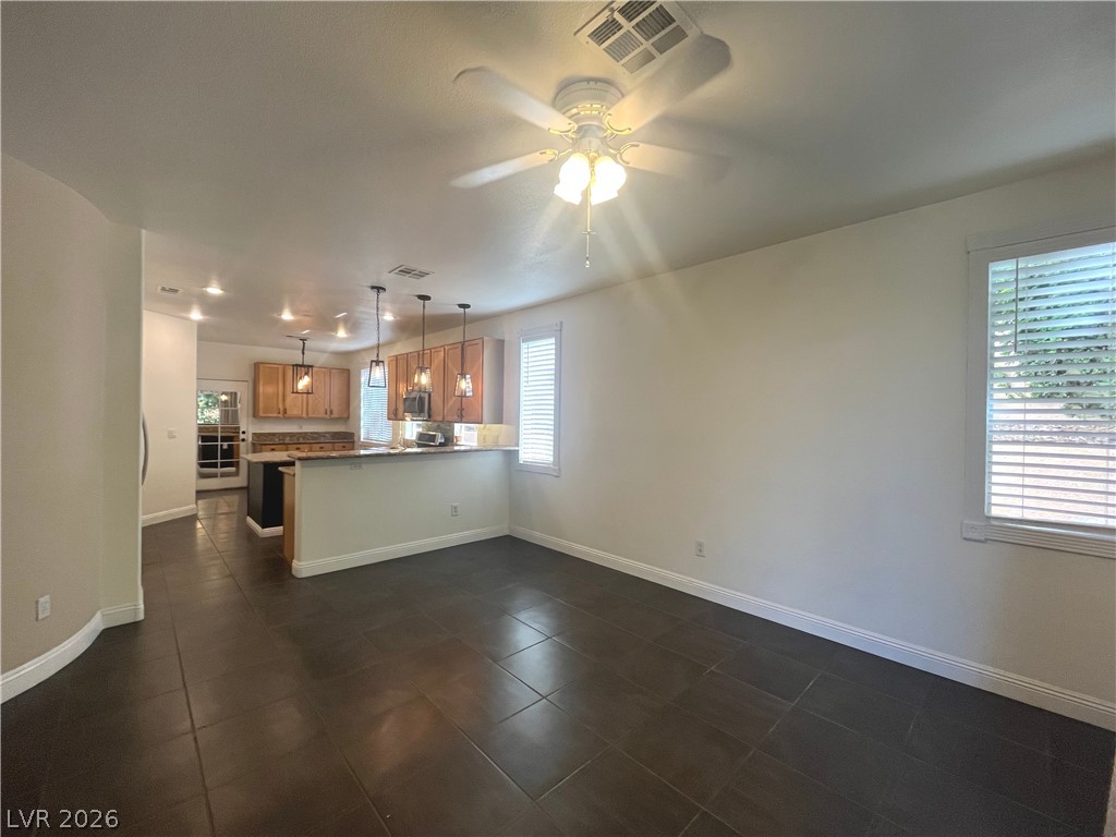 1809 Snow Spring Lane Las Vegas, NV 89134 - Photo 19 of 75 The family room open to the kitchen w/stoned fireplace, ceiling fan & light, ceramic tile floors and two tone paint.