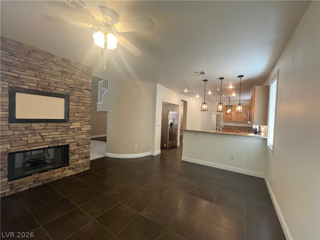 1809 Snow Spring Lane Las Vegas, NV 89134 - Photo 20 of 75 The family room open to the kitchen w/stoned fireplace, ceiling fan & light, ceramic tile floors and two tone paint.