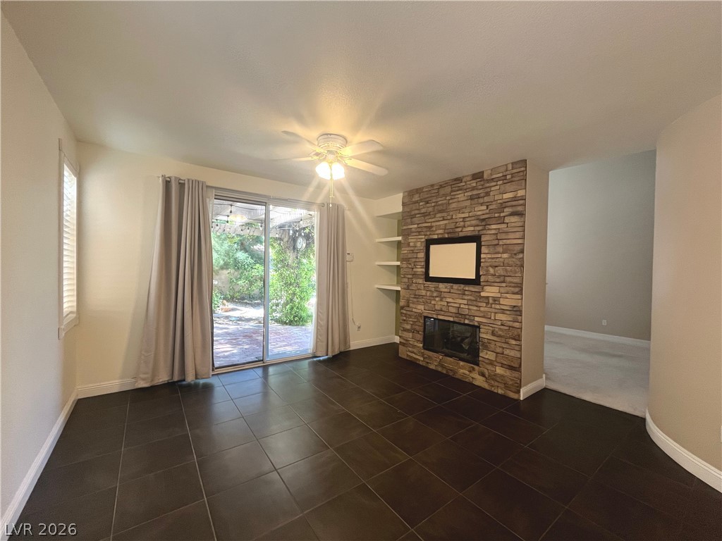 1809 Snow Spring Lane Las Vegas, NV 89134 - Photo 21 of 75 The family room open to the kitchen w/stoned fireplace, ceiling fan & light, ceramic tile floors and two tone paint.